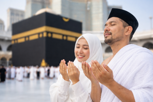 pasangan jamaah umroh sedang berdoa di depan ka'bah masjidil haram mekkah dengan pakaian ihram dan hijab putih