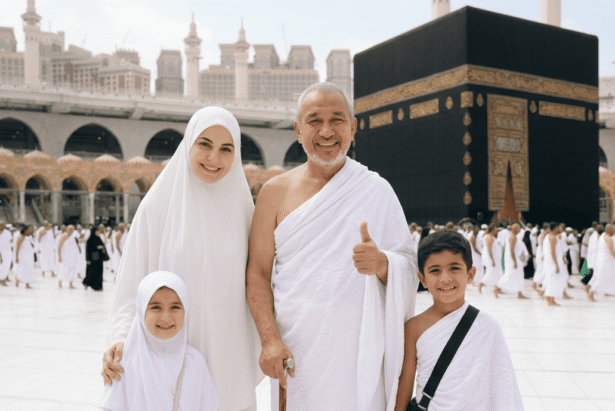 Seorang kakek, wanita berhijab, dan dua anak kecil mengenakan ihram putih di depan Ka'bah, Makkah.